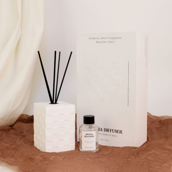 Artistic white geometric reed diffuser with black sticks on brown paper background