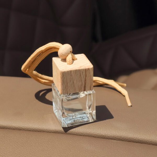 close-up of glass car diffuser bottle with rope and bead