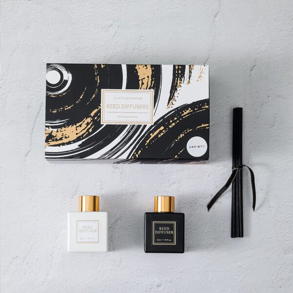 Open gift box showing two fragrance bottles and sticks