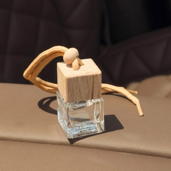 close-up of glass car diffuser bottle with rope and bead