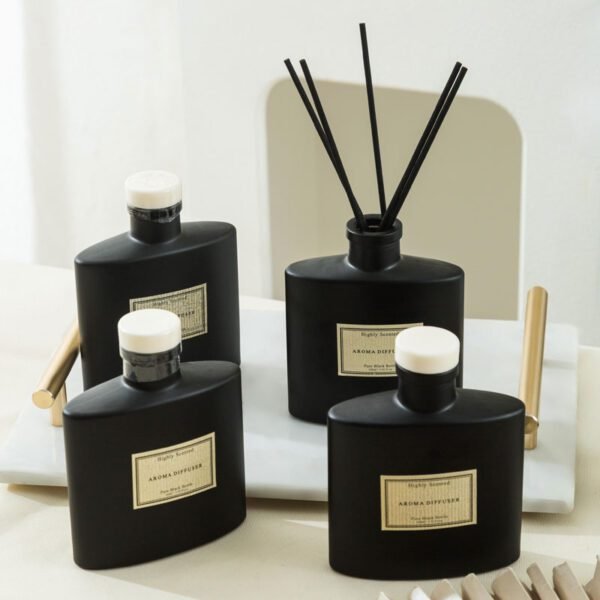 lineup of matte black glass diffusers with white caps and reeds