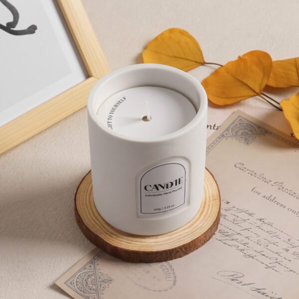 close-up of matte white candle jar with cotton wick