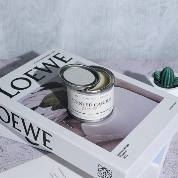 lifestyle shot: Amber Allure tin candle on desk with notebook